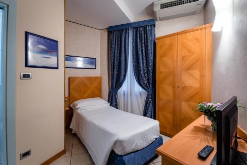a bedroom with a bed and a desk and a television at Hotel Centrale in Bologna