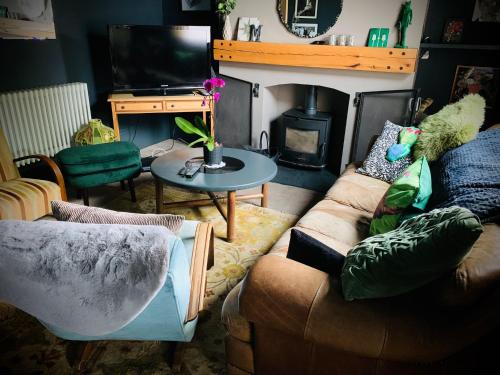 uma sala de estar com um sofá e uma lareira em The green house em Portsmouth