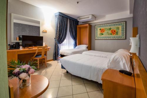 a hotel room with a bed and a desk and a television at Hotel Centrale in Bologna