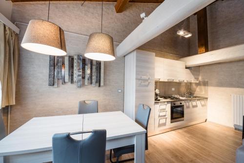 a kitchen and dining room with a white table and chairs at Hotel Centrale in Bologna