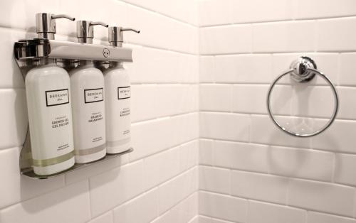a bathroom with two white bottles on a wall at The Plainfield Inn in Plainfield