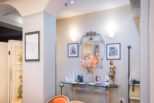 a room with a mirror and a table with flowers at Hotel Centrale in Bologna