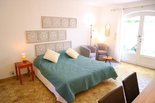 ein Schlafzimmer mit einem Bett mit einer grünen Decke in der Unterkunft Studio 14 - LES SUITES DE ROBINSON - Résidence avec piscine en bord de Siagne, à Mandelieu-La-Napoule in Mandelieu-la-Napoule