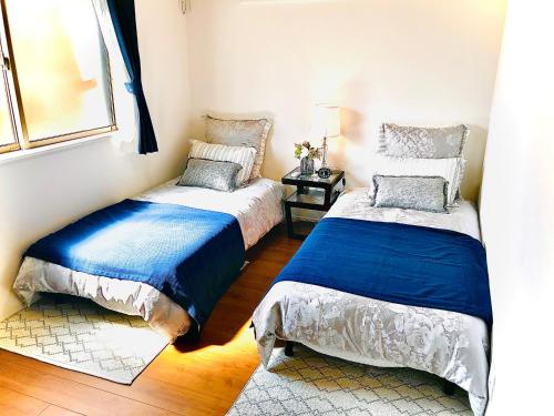 ein Schlafzimmer mit zwei Betten und einem Fenster in der Unterkunft 八ヶ岳ヴィラ・M9 in Hokuto