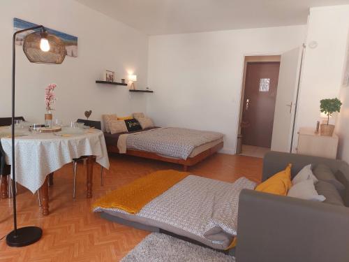 uma sala de estar com uma cama e uma mesa em Studio 25m2 tt confort dans Résidence Thermes FOCH centre ville Dax em Dax
