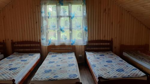 2 camas en una habitación con ventana en Sodyba pas Juozą, en Milkai