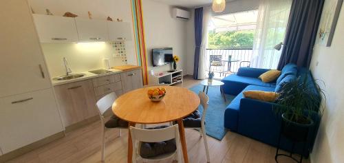 斯普利特的住宿－Apartment Rosie，厨房以及带桌子和蓝色沙发的客厅。