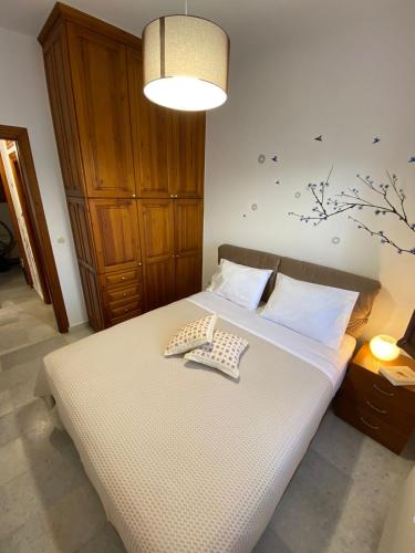 a bedroom with a bed with white sheets and a lamp at On the road house in Apérathos