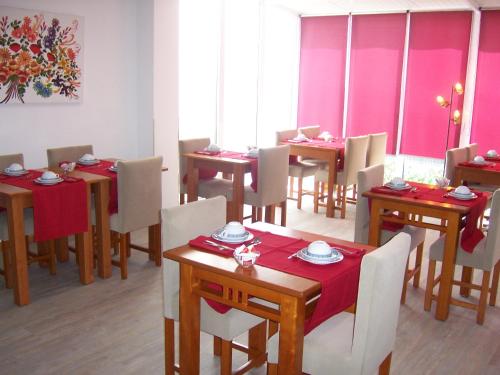 comedor con mesas, sillas y paredes rosas en Hotel Santa Apolonia, en Bragança