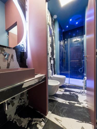 a bathroom with two toilets and a sink and a shower at Pescara Blu B&B in Pescara