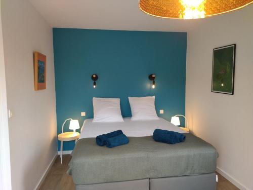 - une chambre avec un grand lit aux murs bleus dans l'établissement Une maison à la plage, à Trégunc