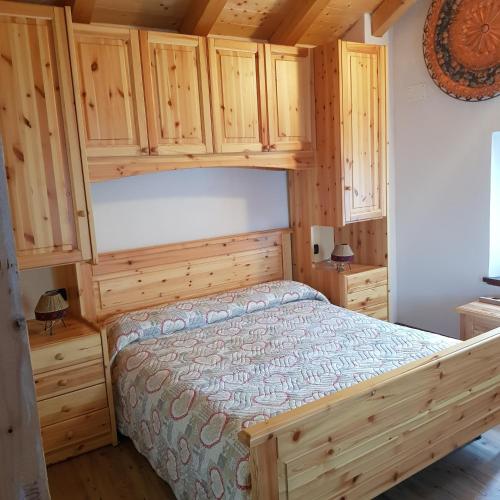 a bedroom with a bed and wooden cabinets at Baita Bocheto Vetriolo Levico Terme in Vetriola