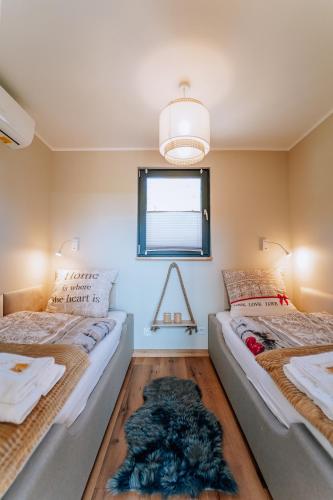 two beds sitting in a room with a window at Szumiące Trawy - Bory Tucholskie in Tleń