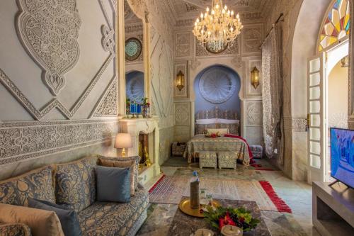 a living room with a couch and a chandelier at Riad Dar El Malaika in El Jadida