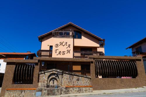 a building with a clock on the side of it at Guesthouse Gaby in Sapareva Banya