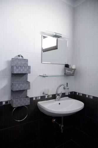 a bathroom with a white sink and a mirror at Guesthouse Gaby in Sapareva Banya