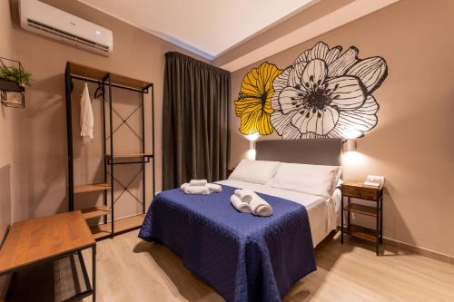 - une chambre avec un lit orné d'une peinture florale sur le mur dans l'établissement ASTARE -short lets in bari carrassi-, à Bari