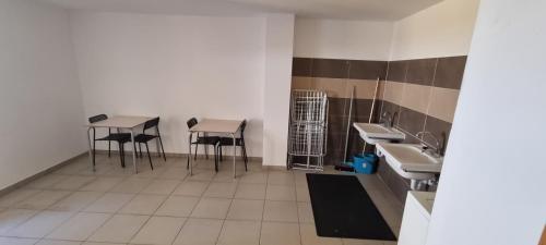 un bagno con due tavoli e due sgabelli di -- Albergue Casa Mariela -- Solo Peregrinos con Credenciales a Torres del Río