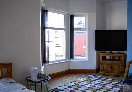 a living room with a flat screen tv and two windows at 33 Turner street in Redcar