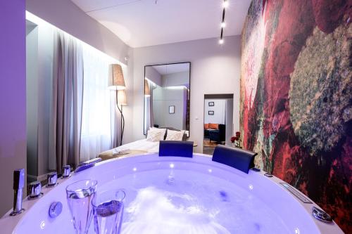 a large bath tub in a room with a bedroom at Arts Apartments - Kraków Old Town in Krakow