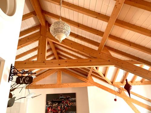 a ceiling with wooden beams and a chandelier at Seven Skirts Prestige Apartments in Nazaré