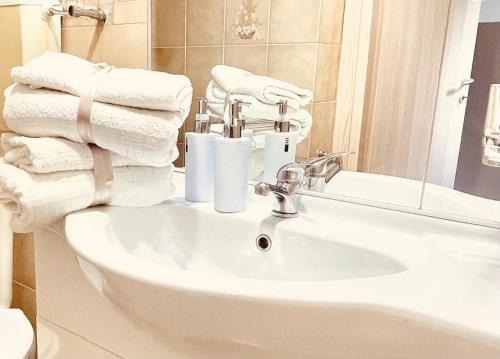 bagno con lavandino, asciugamani e specchio di Pigna Tommy House a Sanremo