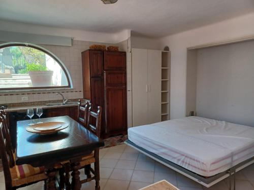Un dormitorio con una cama, una mesa y un escritorio. en Villa Martina, en Isquia