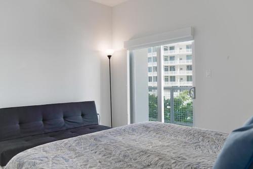 a bedroom with a bed and a large window at Wynwood Modern 1 Bedroom in Miami