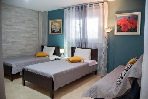 プレベザにあるVilla DKのベッド2台と窓が備わる客室です。