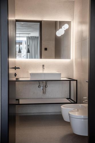 a bathroom with a sink and a toilet and a mirror at Marchegg Apartments in Naturno