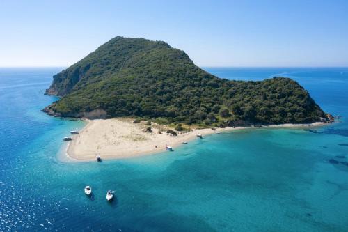 an island in the ocean with boats in the water at Daily Cruises Private Yachts in Zakynthos Town