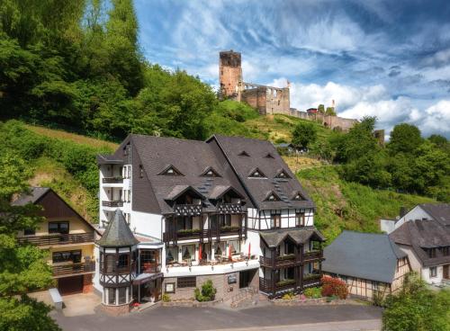 a house on a hill with a castle in the background at Hotel Burgfrieden in Beilstein