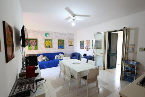a living room with a table and a blue couch at Family apartment in Torre Pali with private 100 sqm garden in Torre Pali 