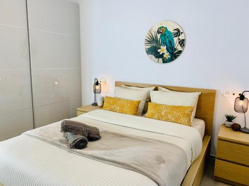 Un dormitorio con dos camas y un reloj en la pared. en Frida cozy house Maspalomas, en Maspalomas
