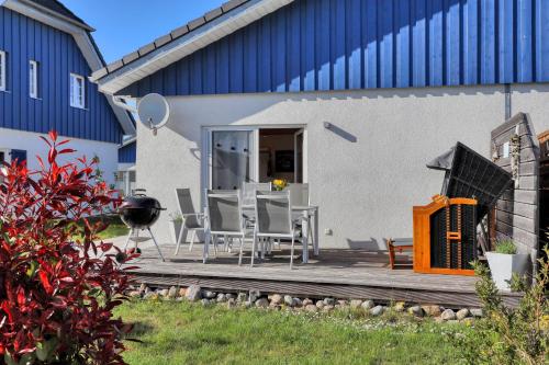 a patio with chairs and a table and a building at La Mer in Altefähr