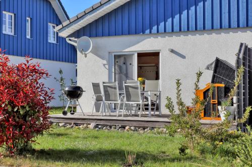 a patio with chairs and a grill in front of a house at La Mer in Altefähr