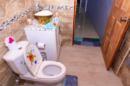a bathroom with a toilet with a statue on the tank at Desired View in Choiseul
