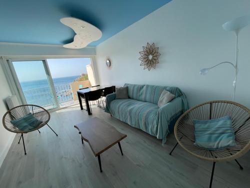 ein Wohnzimmer mit einem Sofa, Stühlen und einem Klavier in der Unterkunft AZUR-Les pieds dans l'eau-Vue sur Mer et Clocher de Collioure en toile de fond - WIFI FIBRE- PARKING Couvert in Collioure