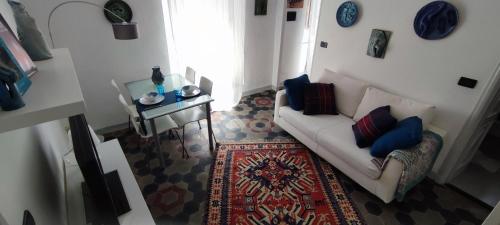 a living room with a white couch and a rug at Ideale per escursionisti, a pochi minuti dal mare e dalle falesie- Casa Celeste in Cisano sul Neva