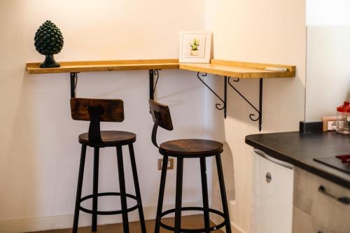 two bar stools under a counter in a kitchen at 111 apartments & rooms in Patti