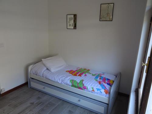 a small bed in a corner of a room at Piso en centro urbano de Puentedeume con terraza in Puentedeume