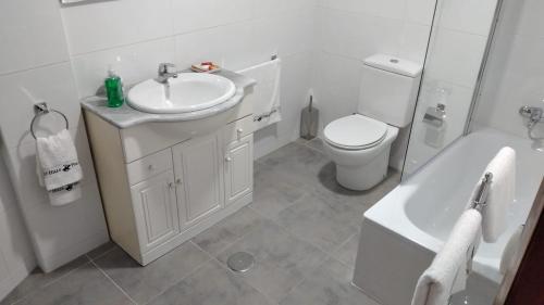 a bathroom with a sink and a toilet and a tub at Piso en centro urbano de Puentedeume con terraza in Puentedeume