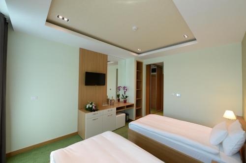 a hotel room with two beds and a sink at Hotel Hedonic in Belgrade