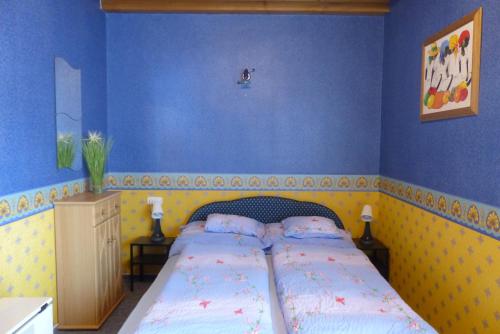 ザラカロシュにあるOrwa apartmanok - Fenyőfa közのベッドルーム1室(青い壁のベッド1台付)