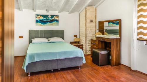 ein Schlafzimmer mit einem Bett, einem Waschtisch und einem Spiegel in der Unterkunft PALMIYE OTEL EVLERI in Datca