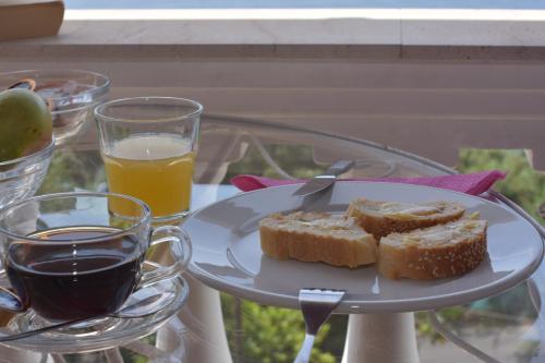 a plate with two slices of bread and a glass of orange juice at Baracunda Apartments in Barbati