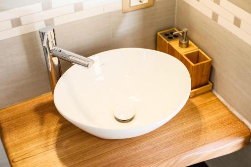 a bathroom with a white sink on a wooden floor at 111 apartments & rooms in Patti