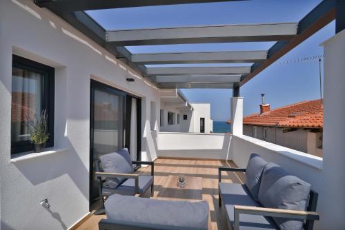 a balcony with chairs and a view of the ocean at Anassa Suites in Leptokaria