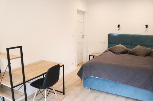 een slaapkamer met een bed, een bureau en een stoel bij Lemon Park Apartments Parking Gratis in Poznań