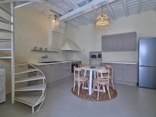 a kitchen with a table and chairs and a refrigerator at Flair Naousa in Naousa